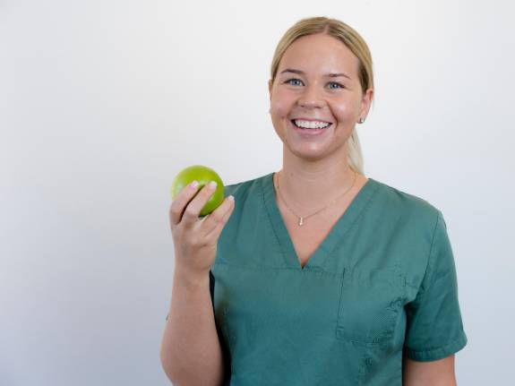 junge Frau hält grünen Apfel in der Hand