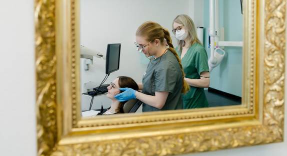 Zahnarzthelferin hält Kiefer der Patientin